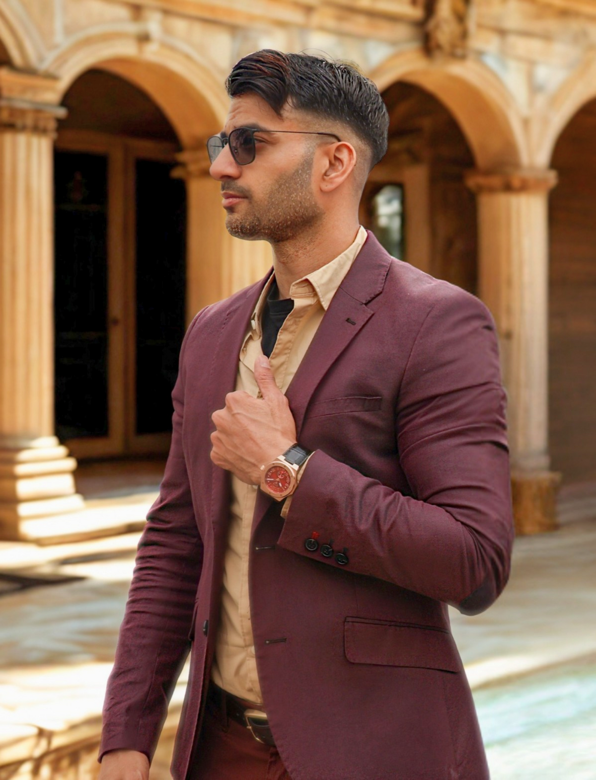 Man wearing VEMPIRE Ember Rose Gold Red watch in an elegant architectural setting