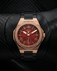 Vempire Ember rose gold red steel watch worn on wrist with black leather background