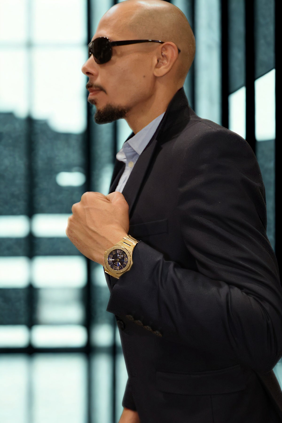 Man wearing VEMPIRE Orion Gold Blue watch adjusting his sleeve in a modern interior
